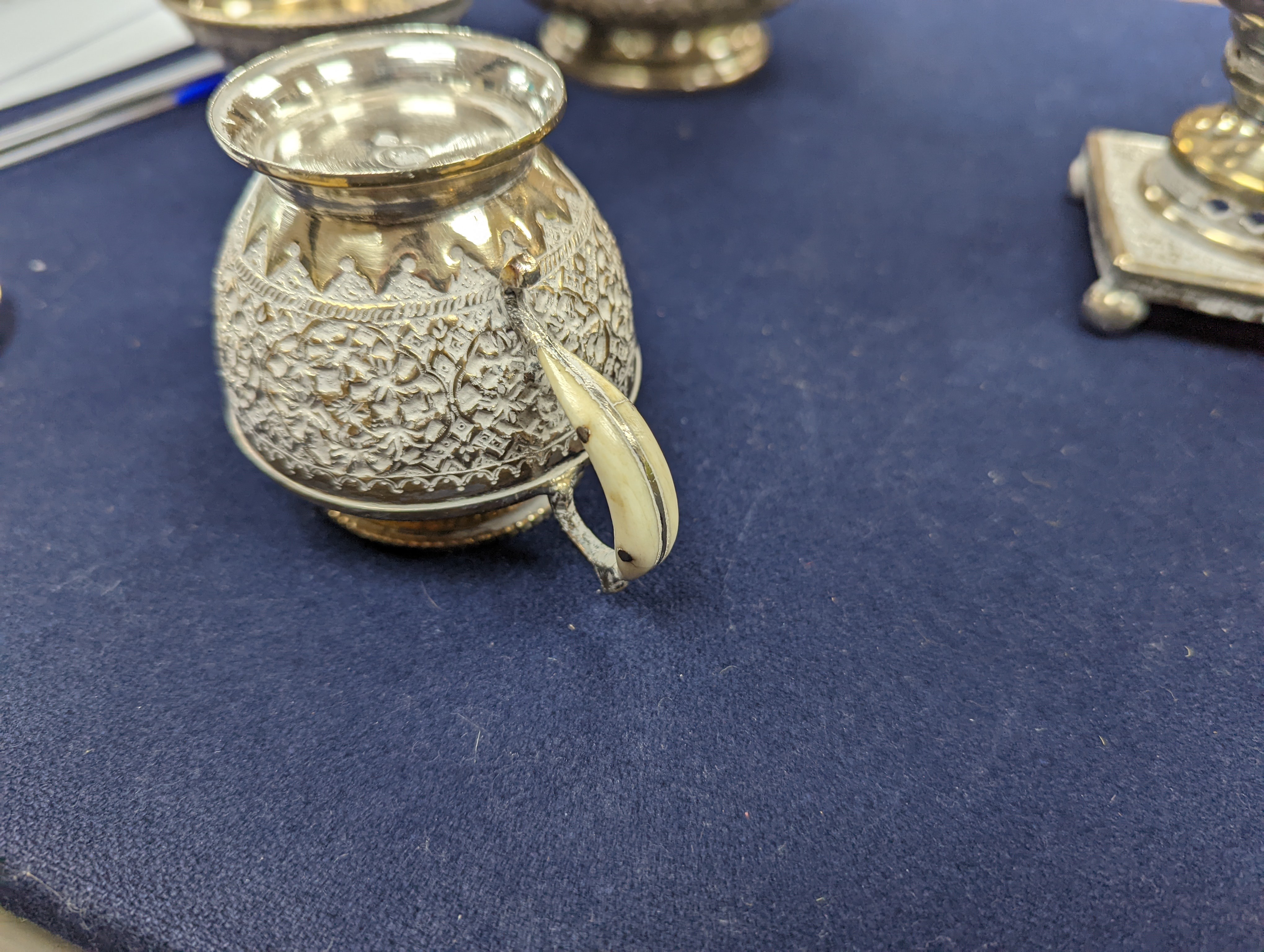 A set of six Persian embossed 84 standard white metal coffee cup holders and matching sugar bowl and cover by Vartan and four other Persian white metal items.